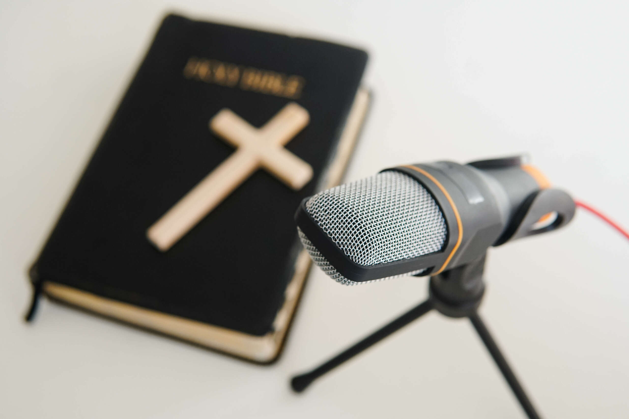 Bible book with microphone on table. Christian radio broadcast. Man records a online podcast.